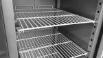 Interior of an empty stainless steel commercial refrigerator with two white wire shelves installed.